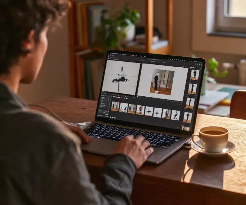Small business owner editing video footage on a laptop, illustrating AI video reframing for social media content