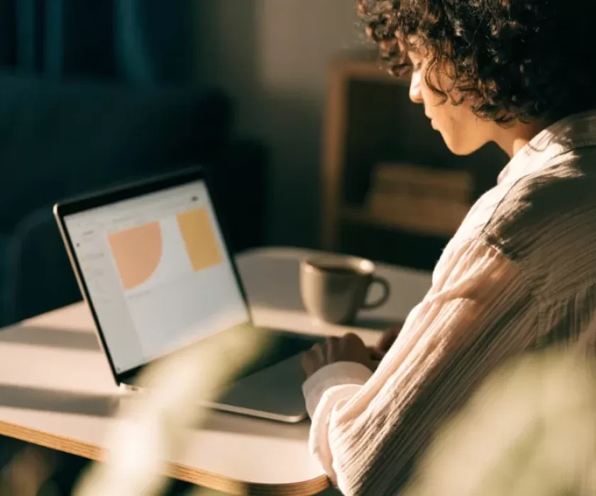 Small business owner using Claude Docs and Slides AI tools on a laptop